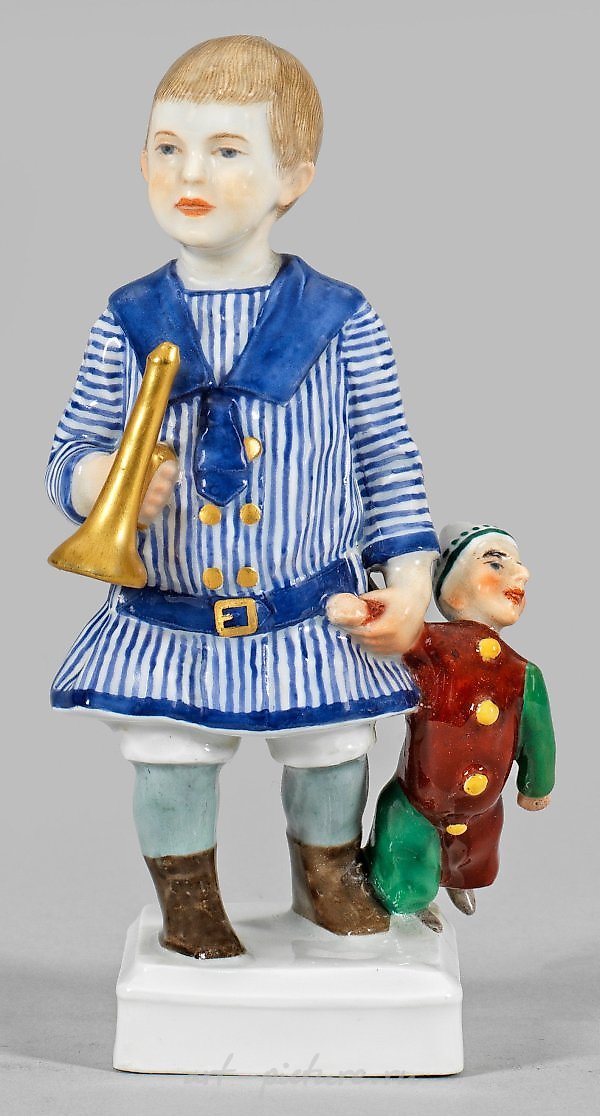 Art Nouveau Figure "Young Boy with Trumpet and Kasperle"

In this exquisite Art Nouveau sculpture, we are presented with a captivating portrayal of a young boy, skillfully crafted with meticulous attention to detail. The artist has masterfully captur